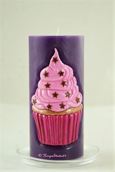 a cupcake candle with pink frosting and stars on it