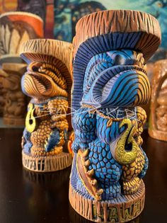 three ceramic vases sitting on top of a table next to each other, one blue and the other yellow