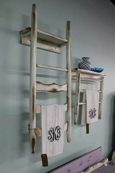 two towels hanging on the wall next to an old ladder and towel rack with monogrammed towels