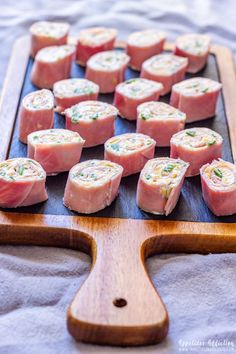 several pieces of food are arranged on a wooden platter, ready to be served