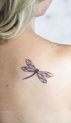 a woman with a dragonfly tattoo on her back