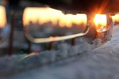 the sun shines through some glasses on top of a skateboard in the snow