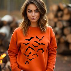 Elevate your Halloween wardrobe this spooky season with our exclusive **Halloween Bats Sweatshirt**. If you're a fan of all things eerie and embrace the spirit of the season with enthusiasm, this sweatshirt is an absolute must-have. Our **Spooky Season Halloween Bats** sweatshirt perfectly captures the essence of Halloween, featuring a playful and slightly mischievous bat design. The bats soar across the fabric, adding a touch of whimsy to your spooky ensemble. In vibrant orange, this sweatshirt not only complements the Halloween color palette but also adds a pop of fun to your fall wardrobe. Whether you're attending a haunted house event, trick-or-treating with friends and family, or just looking to get into the Halloween spirit, our sweatshirt sets the tone with style. But that's not all Orange Long Sleeve Halloween Sweater, Horror Long Sleeve Sweatshirt For Halloween, Orange Crew Neck Halloween Sweatshirt, Halloween Graphic Print Sweatshirt, Spooky Halloween Crew Neck Sweater, Horror Style Crew Neck Sweatshirt For Fall, Horror Crew Neck Sweatshirt For Fall, Fall Horror Crew Neck Sweatshirt, Halloween Color Palette