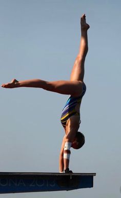 a person doing a handstand on a beam