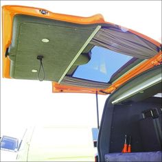 an orange car with its roof open and the sun shining