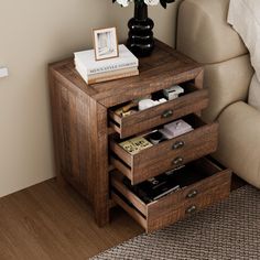 a small wooden table with drawers and flowers on it next to a couch in a living room