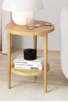 a table with a book and glasses on it next to a white couch in a living room