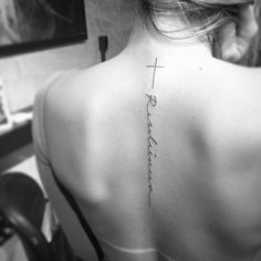 the back of a woman's neck with a cross on it and words written in cursive writing