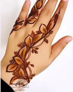 a woman's hand is decorated with hendi and flower designs on her palm