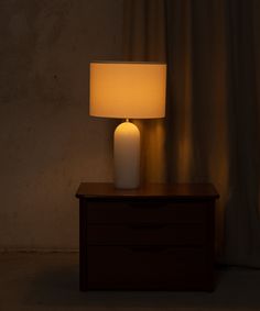 a white lamp sitting on top of a wooden table