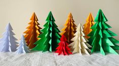 five different colored paper christmas trees on a table