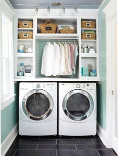 a washer and dryer in a laundry room with shelves on the wall above them