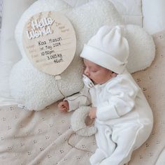 a baby is sleeping next to a teddy bear