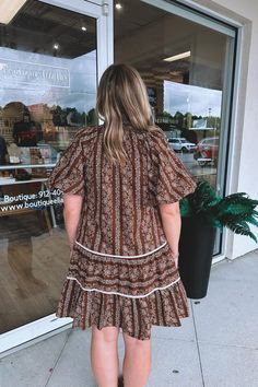 Living out our Southern Chic daydreams in this tiered mini dress. Gorgeous, puff-sleeve, design and a boho inspired floral pattern. Notch, v-neckline with a ruched collar. This dress features hidden side pockets and a built-in lining. Tie straps in the front with a gold metal detail at the ends. Emmy is seen wearing a size medium. Self: 100% cotton Contrast: 80% polyester, 20% cotton Lining: 100% polyester Tiered Mini Dress, Metal Detail, Sweater Coats, Tee Shop, Skirt Pants, Dress Accessories, Long Tops, Long Sleeve Sweater, Puff Sleeve