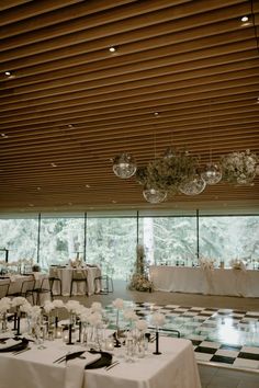 an indoor wedding venue with tables and chairs set up for a formal function in front of large windows