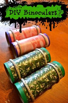 three rolled up rolls of paper sitting on top of a wooden table with the words diy binoculars