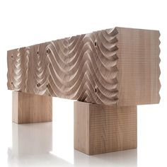 a wooden bench made out of wood with wavy designs on the top and bottom, sitting in front of a white background