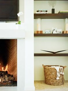 a living room with a fire place and bookshelves in front of the fireplace