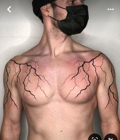 a man with no shirt wearing a face mask and lightning tattoo on his chest,