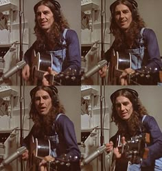 a man with long hair and headphones on holding a guitar in front of his face