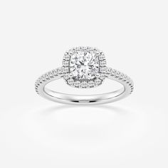 a white gold ring with an oval halo setting and round diamonds on the band, set in