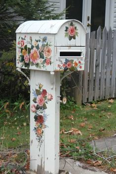 an old white mailbox with flowers painted on it