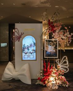 a room with flowers and pictures on the wall, including a white bow - tie