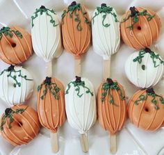 there are many pumpkins on the sticks with icing and green sprinkles