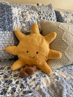 a yellow stuffed animal laying on top of a blue and white bedspread with pillows