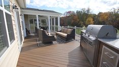 an outdoor deck with grill and seating area