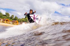 a man riding a surfboard on top of a wave in the ocean next to a beach