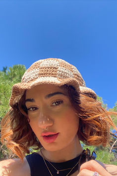 a woman with red hair wearing a brown hat and black shirt is posing for the camera