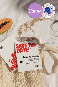 two save the date cards sitting on top of a table next to some wine glasses