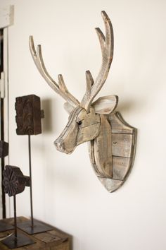 a wooden deer head mounted to the side of a wall