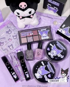 various items are displayed on a purple cloth with a stuffed animal in the background, including nail polish and makeup