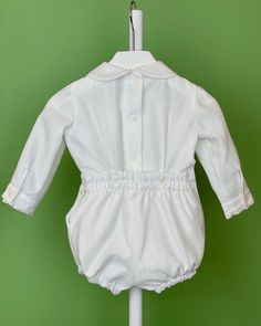 An elegant two-piece set for baby boys to wear during any special occasion. The top has a peter pan collar, handmade pleats, and long sleeves; it has buttons on the back for closure. The bottom is bubbles with buttons on the sides for closure and an elastic band on the back. The interior, or lining, is made with cotton fabric, while the exterior is with white organza. Dry clean 2 piece set Interior: 100% cotton; exterior: 100% polyester Made in Spain Final Sale Elegant Long Sleeve Sets With Pintucks, Elegant Fitted Sets With Pintucks, Classic White Collared Sets, Classic Long Sleeve Sets For Baptism, Fitted Long Sleeve Sets With Button Cuffs, Fitted Sets With Button Cuffs And Long Sleeves, Long Sleeves Outfit, Sleeves Outfit, Bubble Outfit