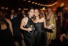 two women standing next to each other at a party