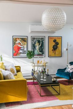 a living room filled with furniture and pictures on the wall