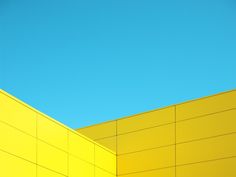 a yellow building with a blue sky in the background