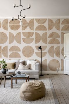 a living room with a couch, coffee table and lamp on the wall in front of it