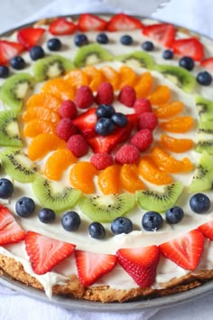 a cake with fruit on top and cream frosting in the shape of a flower