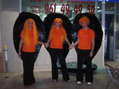 three women in orange shirts standing next to each other