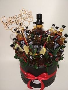 a basket filled with lots of bottles of liquor sitting on top of a white table