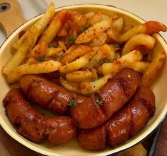 a plate full of cooked sausages and french fries