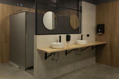 a bathroom with two sinks and mirrors on the wall