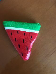 a piece of cake shaped like a slice of watermelon on a wooden table