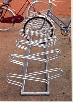 several bicycles are parked next to each other on the ground in front of a fence