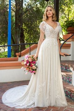 a woman in a wedding dress standing on steps