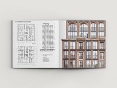 an open book with architectural drawings on the front and back pages showing windows, balconies, and floor plans