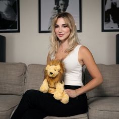 a woman sitting on a couch holding a stuffed animal